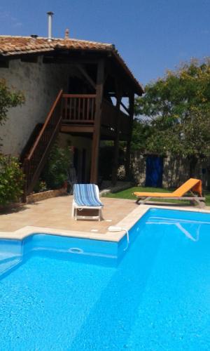 - une piscine avec une chaise à côté d'une maison dans l'établissement Maison de campagne, à Lacépède