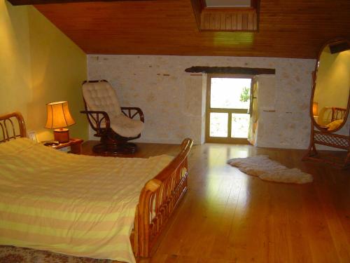 une chambre avec un lit, une chaise et une fenêtre dans l'établissement Maison de campagne, à Lacépède