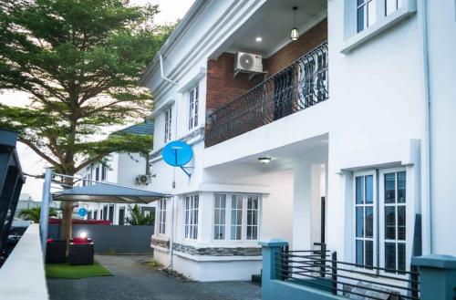 a white building with a balcony and a tree at Casa Eko in Lekki