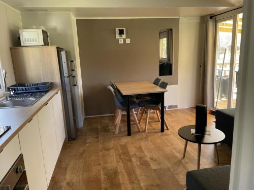 Il comprend une petite cuisine avec une table et un réfrigérateur. dans l'établissement Les Oyats 4 étoiles emplacement AJ17 2CH 2SDB 6 pers, à Seignosse