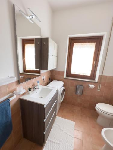 un bagno con lavandino, WC e specchio di Residenza Lucia a Campagnano di Roma