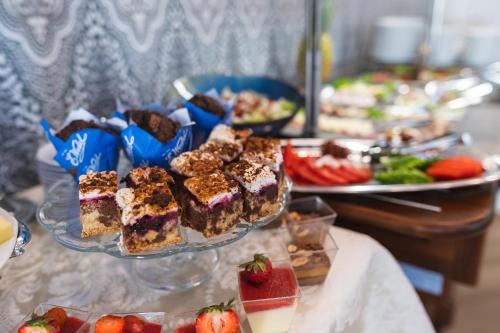 a buffet of food with cakes and strawberries on a table at Moris Boutique Beach Hotel in Gdańsk