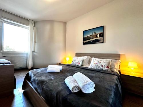 a bedroom with a large bed with towels on it at Blue wave apartment by the sea in Lignano Sabbiadoro