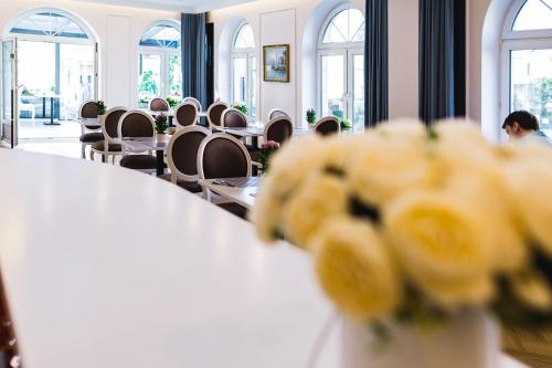 a room with a table and chairs and windows at Moris Boutique Beach Hotel in Gdańsk