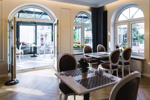 a restaurant with tables and chairs and windows at Moris Boutique Beach Hotel in Gdańsk