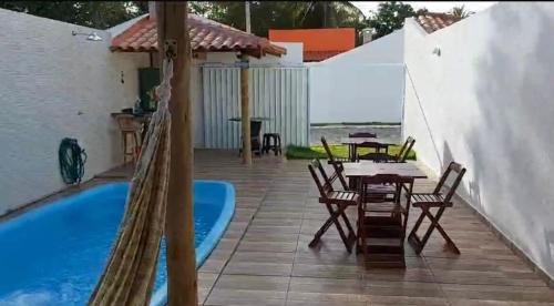 a patio with a table and chairs next to a pool at Casa de praia Jauá in Camaçari