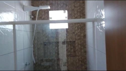 a bathroom with a shower with a glass door at Casa de praia Jauá in Camaçari