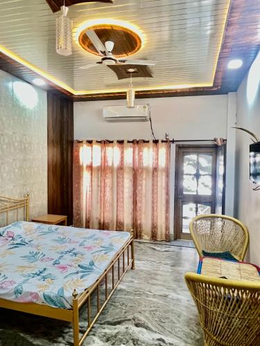 a bedroom with a bed and chairs in a room at Aaranya Retreat by Agrawal s in Haridwār