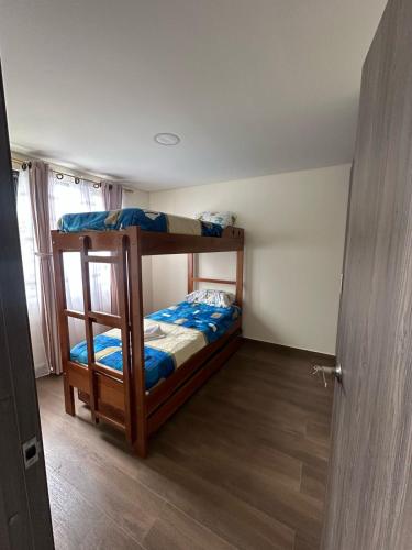a bedroom with two bunk beds and a door at Apartamento Ubate in Ubaté