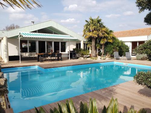 une image d'une piscine en face d'une maison dans l'établissement Villa Seychelles, à Nieul-sur-Mer