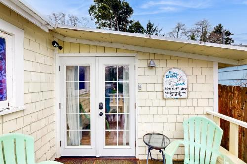 a house with two chairs and a door at Happy Crabby Shack in Rockaway Beach