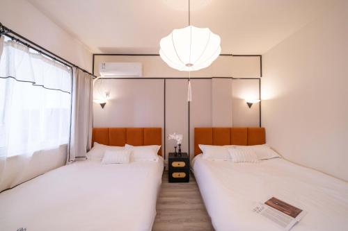 two beds in a room with a large window at Molly Homestay - Nanjing East Road the Bund 3-Bedroom with Elevator Apartment in Shanghai