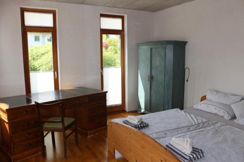 a bedroom with a desk and a bed and a dresser at Stadtvilla in Murnau am Staffelsee
