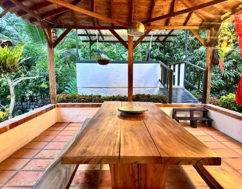- une table en bois sur une terrasse avec un écran dans l'établissement Casa Verano la rumbita Naturaleza, Piscina y Rio, à Santa Fe de Antioquia