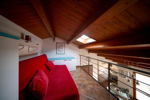a red couch in a room with wooden ceilings at Appartamento incantevole in centro città in Alghero