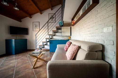 a living room with a couch and a brick wall at Appartamento incantevole in centro città in Alghero