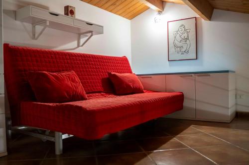 a red couch in the corner of a room at Appartamento incantevole in centro città in Alghero