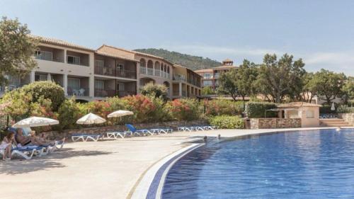 - une piscine dans un complexe avec des chaises dans l'établissement Appt 31m2 - parking - wifi - clim - piscine, à Roquebrune-sur Argens