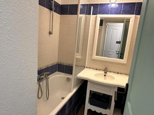 une salle de bain avec une baignoire, un lavabo et un miroir dans l'établissement Appt 31m2 - parking - wifi - clim - piscine, à Roquebrune-sur Argens