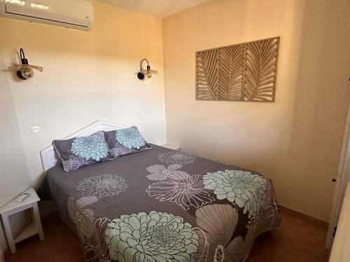 une chambre avec un lit et un tableau au mur dans l'établissement Appt 31m2 - parking - wifi - clim - piscine, à Roquebrune-sur Argens