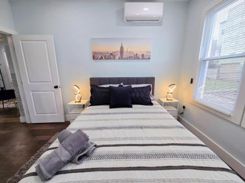a bedroom with a large bed with two lamps at Modern 2BR Apartment Near New York City in Jersey City