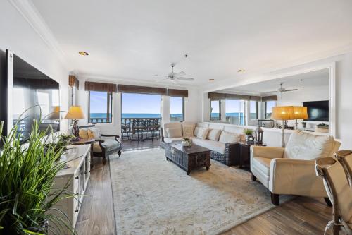 Una sala de estar con muebles blancos y vista al mar. en H1070 Hamilton Cove Villa 10-70, en Avalon