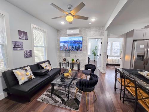 a living room with a black couch and a table at Modern 2BR Apartment Near New York City in Jersey City