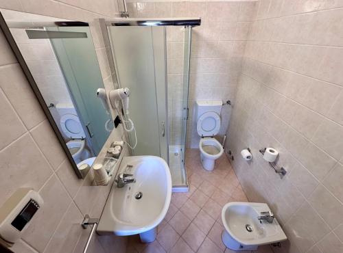 a bathroom with a sink and a toilet and a mirror at Alloggi Centrale in Porto Tolle