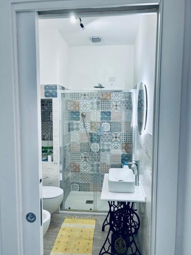 a bathroom with a shower with a sink and a toilet at Sedile Dei Nobili Apartment in Tropea
