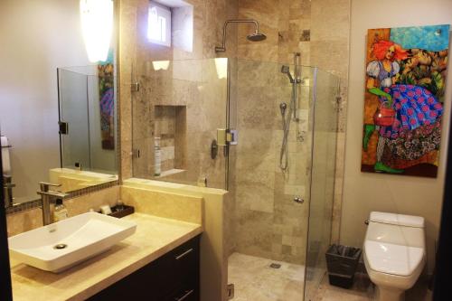 a bathroom with a shower and a sink and a toilet at Pinnacle Resorts 180 in Puerto Vallarta