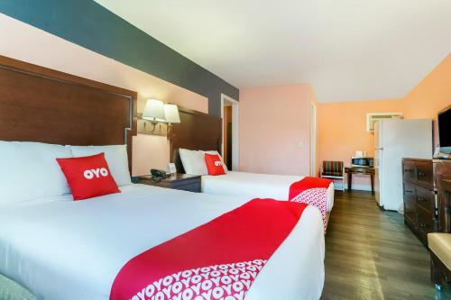 two beds in a hotel room with red pillows at OYO Hotel Myrtle Beach Kings Hwy in Myrtle Beach