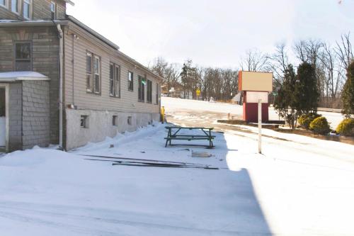 a picnic table in the snow next to a building at OYO Hotel Wilkes-Barre East in Wilkes-Barre