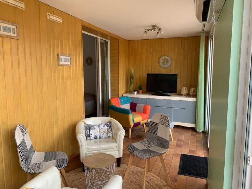- un salon avec des chaises et une télévision dans l'établissement Au bord de la mer, à Saint-Aygulf