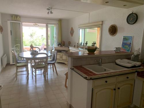 une cuisine avec une table et une salle à manger dans l'établissement Au bord de la mer, à Saint-Aygulf