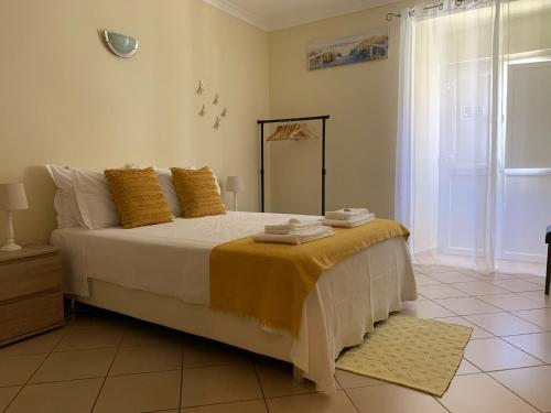 una camera da letto con un letto grande con cuscini gialli di Blue Moon Guesthouse a Lagos