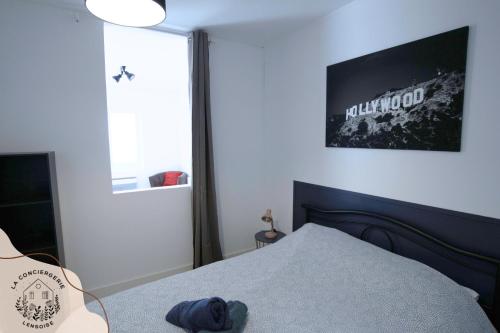a bedroom with a bed and a television on the wall at Le 101 de Serge in Noeux-les-Mines