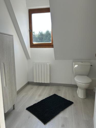 une salle de bain avec toilettes et fenêtre dans l'établissement Le Cottage aux portes de Deauville, à Bonneville-sur-Touques