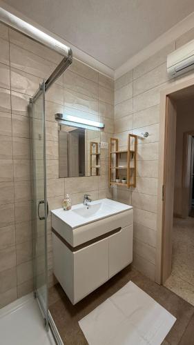 a bathroom with a sink and a glass shower at Flat in St Julians sea view in St Julian's