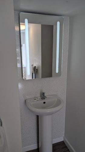 a bathroom with a white sink and a mirror at Duke of Cornwall in St Austell