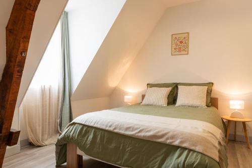 une chambre avec un lit dans un grenier dans l'établissement Gîte de Caillou, à Berbiguières