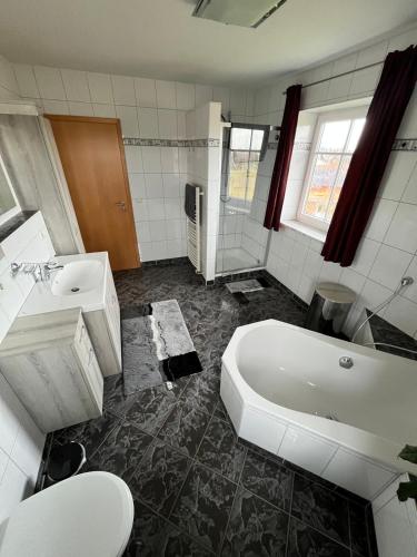 a bathroom with a tub and a sink and a toilet at Wohnung mit Bergblick in Waging am See