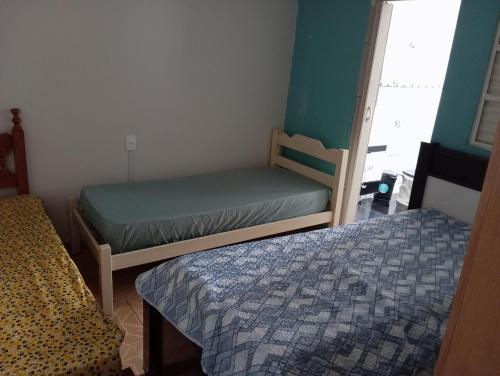 a small bedroom with two beds and a window at Casa de Fundo da Martinha in Campinas