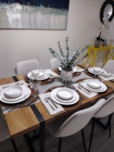 a dining room table with white plates and silverware at The Modern Recharging Station in Marietta