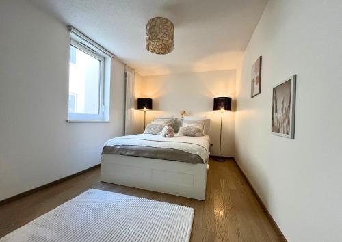a bedroom with a bed with two lamps and a window at Appartement Vue Canal in Strasbourg