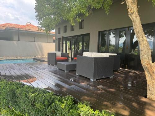 a wooden deck with furniture and a house at Pecanwood Relaxing Villa 5 bedroom with pool in Hartbeespoort