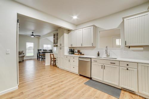 a kitchen with white cabinets and a hard wood floor at 1 Mi to Table Rock Lake Home with Furnished Patio! in Blue Eye