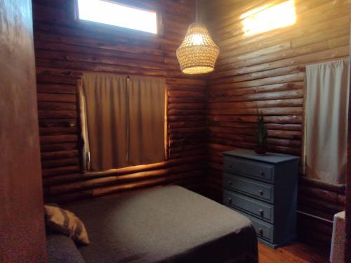 a bedroom with a bed and a window and a dresser at Cabaña La Obsidiana in San Miguel del Monte