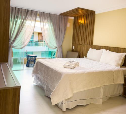 a bedroom with a large bed with two towels on it at Star Palace Hotel Jeri in Jericoacoara