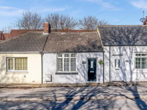 a white house with a black roof at Nook Cottage in Durham
