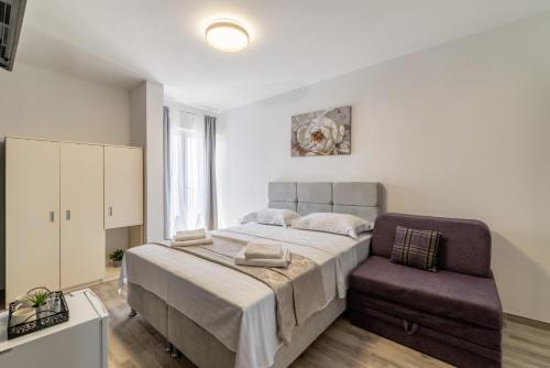 a bedroom with a large bed and a chair at Villa Valamare in Podstrana